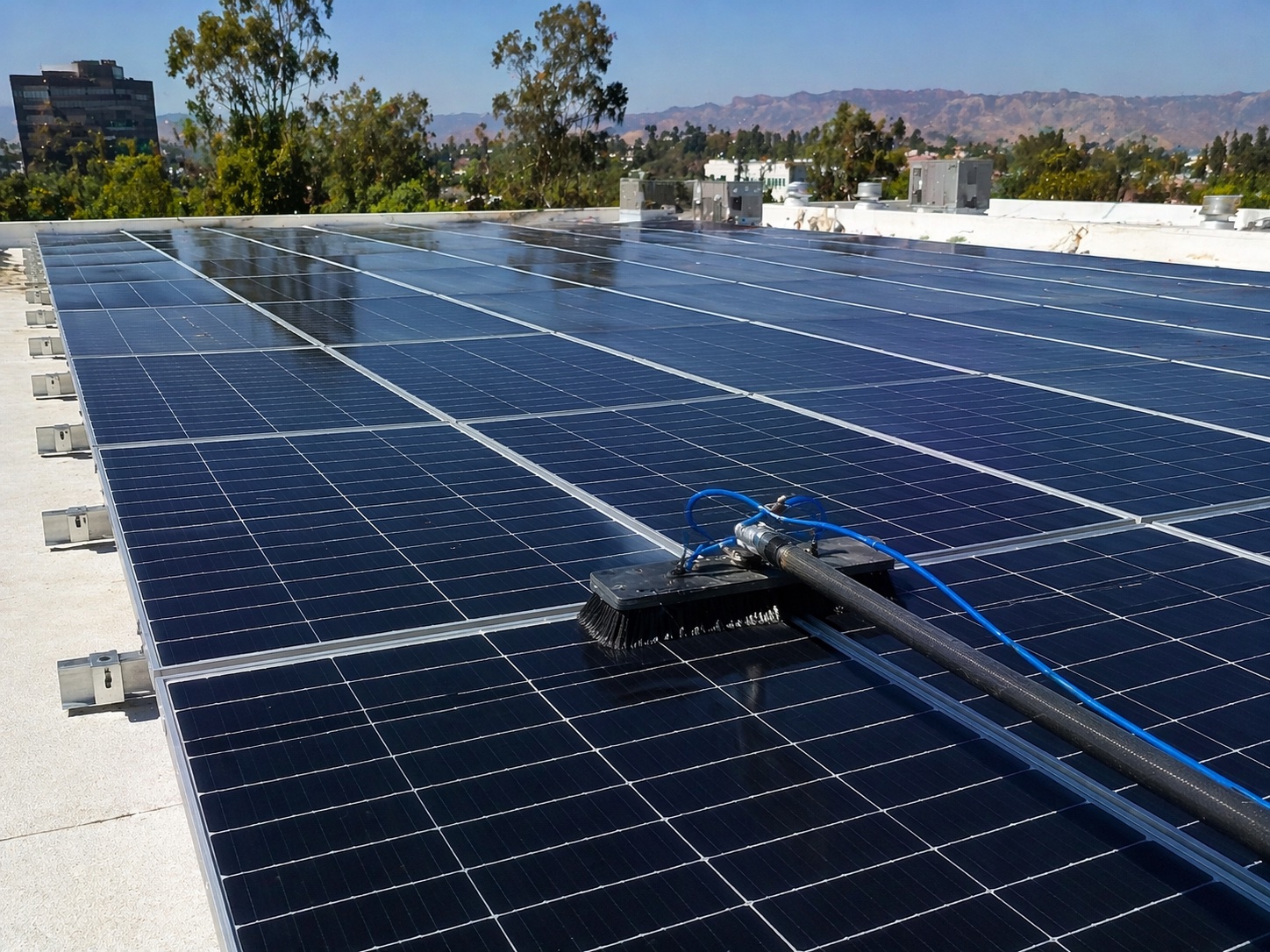 Commercial solar panel cleaning in Irvine, Orange County — large flat-roof array being cleaned with pure water soft-bristle system by Bright Mountains Solar Cleaning